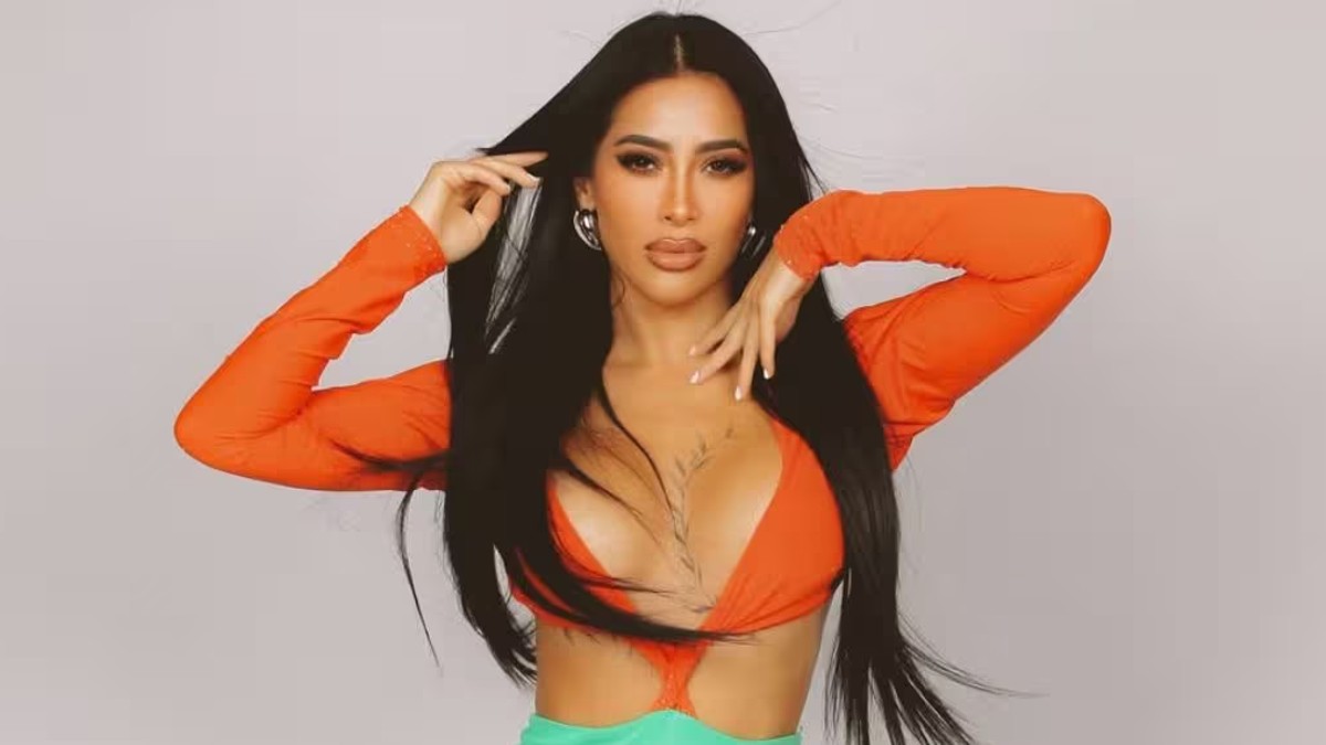 En la imagen aparece Kim Shantal con un atuendo en color naranja, posando con las manos elevadas a la cara. En la imagen aparece Kim Shantal con un atuendo en color naranja, posando con las manos elevadas a la cara.