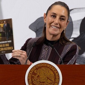 Claudia Sheinbaum mostrando su nuevo libro en conferencia matutina.