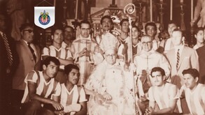 Imagen en blanco y negro, con tinte sepia, del Cardenal José Garibi Rivera rodeado por jugadores del equipo de fútbol Chivas (El Rebaño Sagrado) en atuendos for