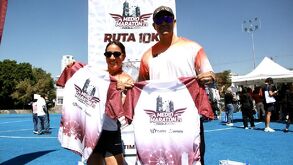un hombre y una mujer mostrando una playera del medio maratón puebla 2025