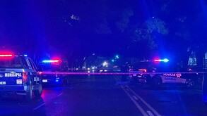 Escena nocturna de Zapopan con patrullas de Policía Municipal y Zapopan con luces rojas y azules encendidas. Una cinta de precaución bloquea la calle.