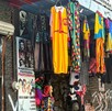 Fachada de una tienda de disfraces en un edificio antiguo. Ropa de Halloween y Carnaval cuelga en ganchos: disfraces de payaso, vestido amarillo y prendas Fachada de una tienda de disfraces en un edificio antiguo. Ropa de Halloween y Carnaval cuelga en ganchos: disfraces de payaso, vestido amarillo y prendas