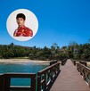 Muelle de madera sobre el agua turquesa en una playa tropical. En la esquina superior izquierda, una foto de perfil de Charles Leclerc con su uniforme rojo Muelle de madera sobre el agua turquesa en una playa tropical. En la esquina superior izquierda, una foto de perfil de Charles Leclerc con su uniforme rojo