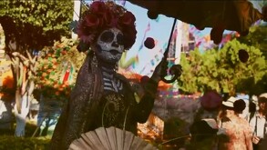 Una catrina con sombrilla durante el esfile en  Ixtlahuacán de los Membrillos