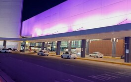 Aeropuerto de Guadalajara de noche con algunos vehículos blancos estacionados