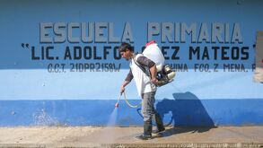 Padre de familia realizando acciones de fumigación y desinfección en una escuela de la Sierra Norte de Puebla.