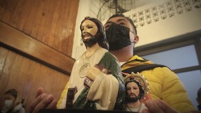 un hombre carga una imagen de san judas tadeo en un templo en puebla