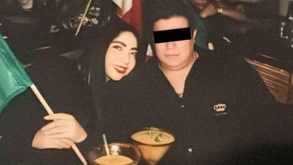 Una mujer y un hombre sentados en la misma mesa compartiendo una bebida.