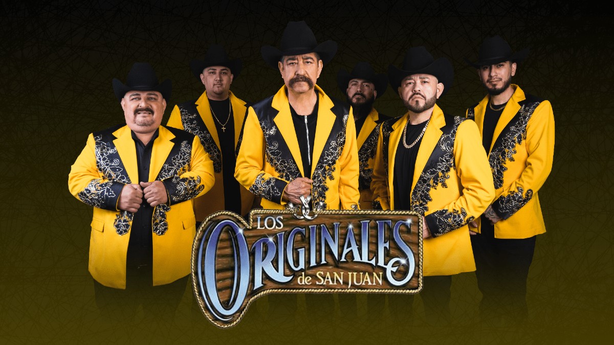 El gobernador de Michoacán, Alfredo Ramírez Bedolla, habla en un podio con banderas de México. Un oficial de seguridad de alto rango está parado a su derecha.