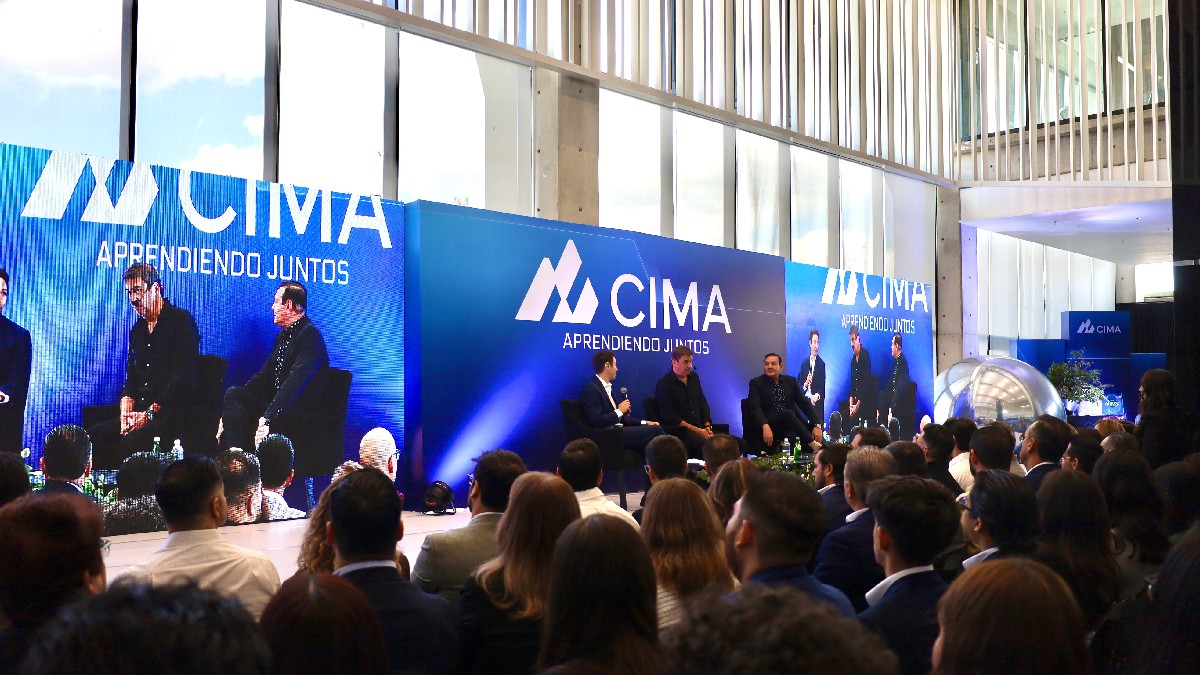 Arturo Elías Ayup junto a Teodoro Martínez, director general de CIMA, y Teodoro Martínez, presidente del Consejo de Administración con expectadores escuchando.