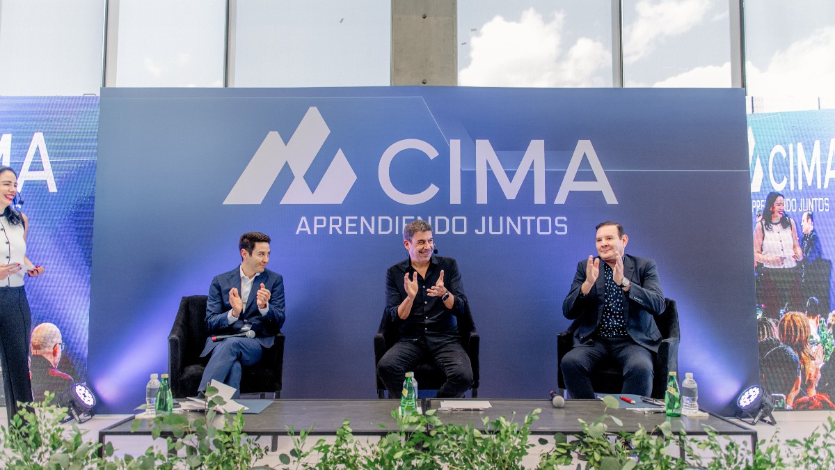 Arturo Elías Ayup, junto a Teodoro Martínez Ramos y Teodoro Martínez Ruiz, en el escenario del foro de CIMA aplaudiendo.