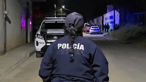 Mujer con una chamarra con las siglas 