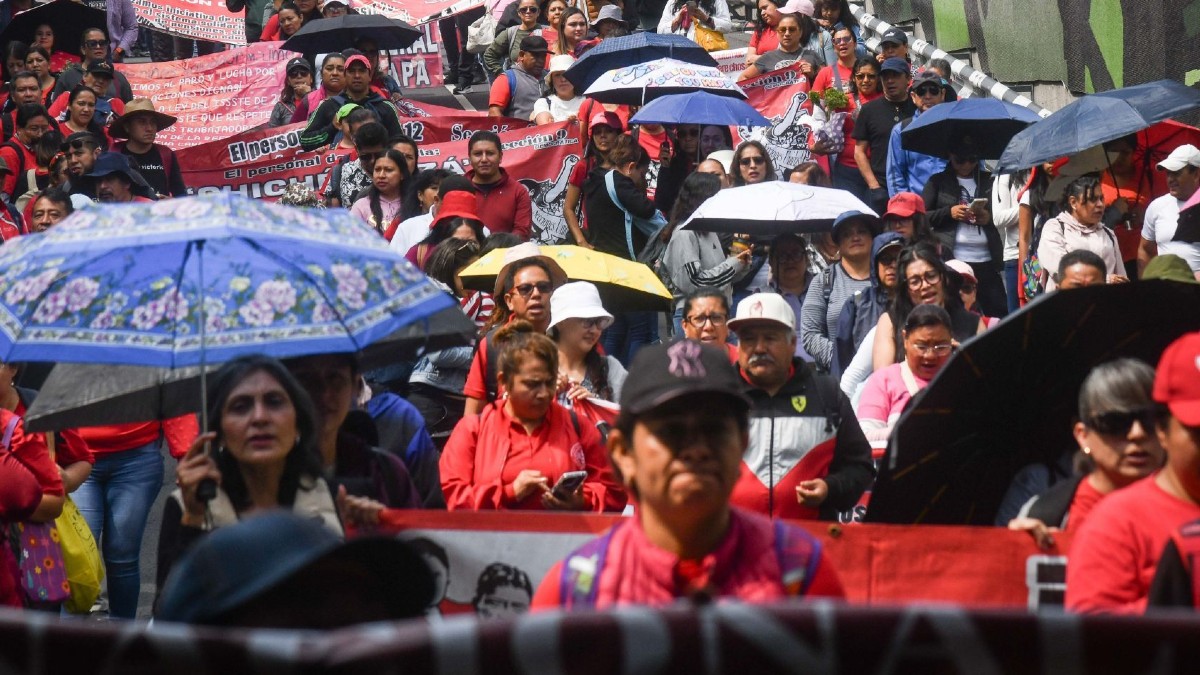 Personas manifestándose en calles de la Ciudad de México con banderines y carteles Personas manifestándose en calles de la Ciudad de México con banderines y carteles