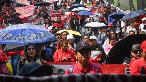 Personas manifestándose en calles de la Ciudad de México con banderines y carteles