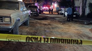 Cinta policiaca acordonando un terreno con camionetas y patrullas de la Policía de Tlaquepaque
