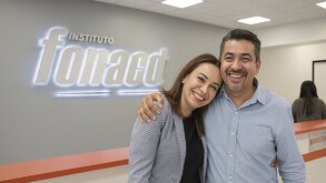 Imagen generada por IA de pareja de hombre y mujer sonriendo a la cámara dentro de las oficinas del Fonacot