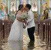 Una pareja filipina conmueve al casarse en una iglesia inundada durante un tifón, simbolizando amor y resiliencia en medio de la adversidad climática. Una pareja filipina conmueve al casarse en una iglesia inundada durante un tifón, simbolizando amor y resiliencia en medio de la adversidad climática.