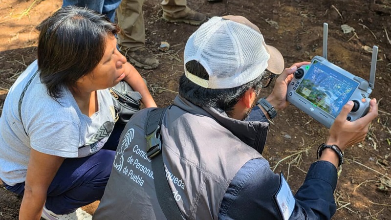 Un hombre y una mujer usan un dron para la búsqueda de un niño desaparecido en la Sierra Norte de Puebla. Un hombre y una mujer usan un dron para la búsqueda de un niño desaparecido en la Sierra Norte de Puebla.