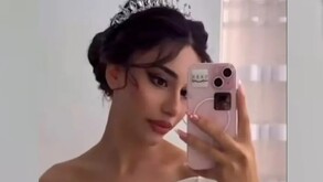 En la imagen aparece una mujer con un vestido de novia tomando una foto frente al espejo con su celular.