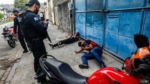 Policías sometiendo a dos hombres en Brasil.