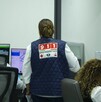 Mujer de espaldas con chaleco del C5 y llamado de emergencias 911 Mujer de espaldas con chaleco del C5 y llamado de emergencias 911