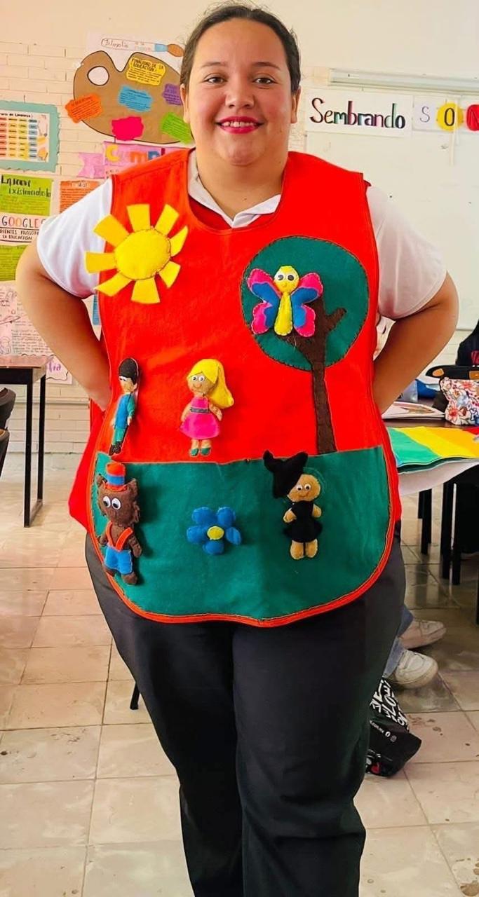 Joven estudiante portando un overol de diferentes colores con figuras primaverales. Joven estudiante portando un overol de diferentes colores con figuras primaverales.