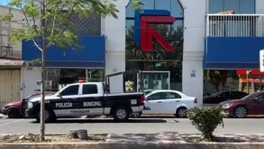 Policía y vehículos estacionados afuera de oficinas recién asaltadas en el municipio de Tehuacán, Puebla.