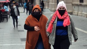 Mujeres con abrigos y bufandas caminando por calles del Centro Histórico de Guadalajara en temporada de frío