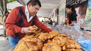 Señor eligiendo una hojaldra en un puesto de pan montado en el Parque del Carmen en Puebla capital.
