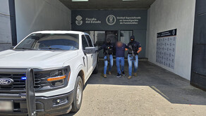 Agentes de la Fiscalía de Jalisco custodiando a un detenido.