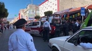 Policías junto a una patrulla tras atender un reporte en calles del centro de Tehuacán, en Puebla.