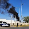 Humo negro saliendo de instalaciones de Aeropuerto de Torreón junto a una patrulla de policía de Torreón
