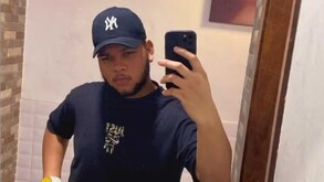 Joven con gorra tomándose una foto frente al espejo con su celular