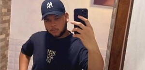 Joven con gorra tomándose una foto frente al espejo con su celular