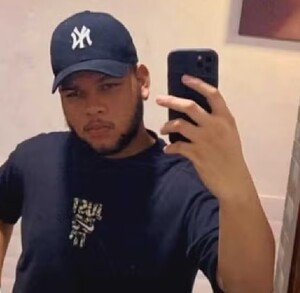 Joven con gorra tomándose una foto frente al espejo con su celular
