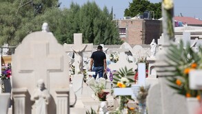 Lápidas en panteón de Torreón de día con una persona de fondo.