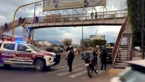 Patrulla y policías abajo de un puente peatonal en la ciudad de Tehuacán, en Puebla.