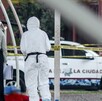 Una mujer y una persona con bata blanca observan el cuerpo sin vida de un hombre, frente a una patrulla de la policía municipal de Puebla. Una mujer y una persona con bata blanca observan el cuerpo sin vida de un hombre, frente a una patrulla de la policía municipal de Puebla.