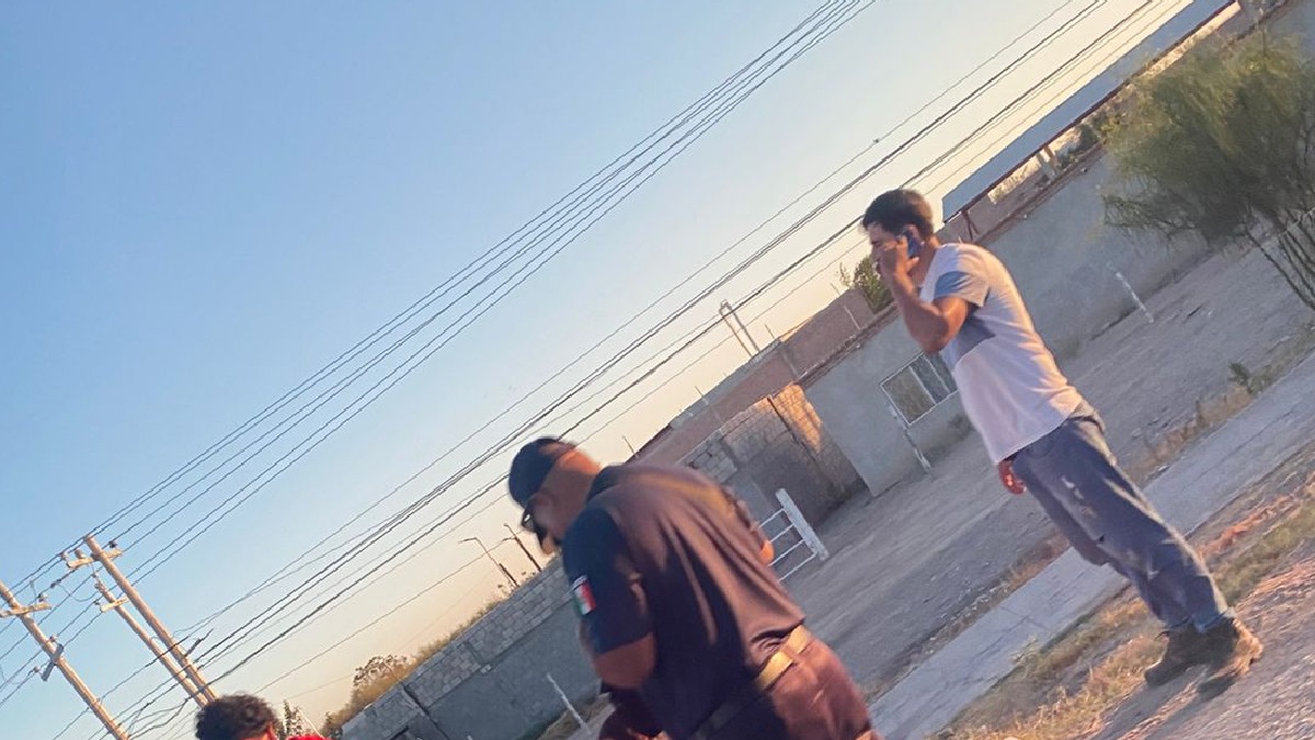 Policía y una persona llamando por teléfono frente a varias casas Policía y una persona llamando por teléfono frente a varias casas