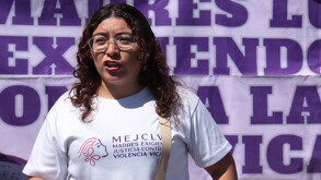 Mujer de pelo rizado con lentes durante una protesta en Puebla.