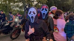 Panel de cinco personas (incluyendo un oficial de policía vial y funcionarios) sentados en una mesa con micrófono. El evento es para discutir la educación vial