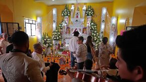 Músicos tocando frente a un altar montado en honor a una persona fallecida en Huaquechula, Puebla.