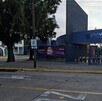 Vista exterior de la entrada principal a la Prepa UNIVA, con el logo azul en un arco. Se ven árboles, un cartel de evento de Halloween, un letrero de 