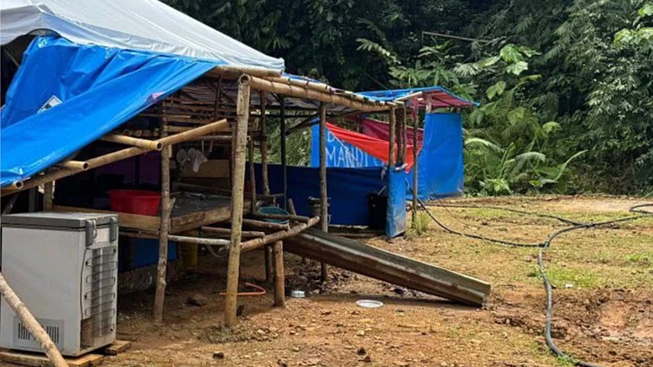 Partes del campamento improvisado con palos de madera, lonas sobrepuestas y al lado un compresor Partes del campamento improvisado con palos de madera, lonas sobrepuestas y al lado un compresor
