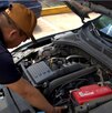 un hombre revisando el motor de un auto seminuevo