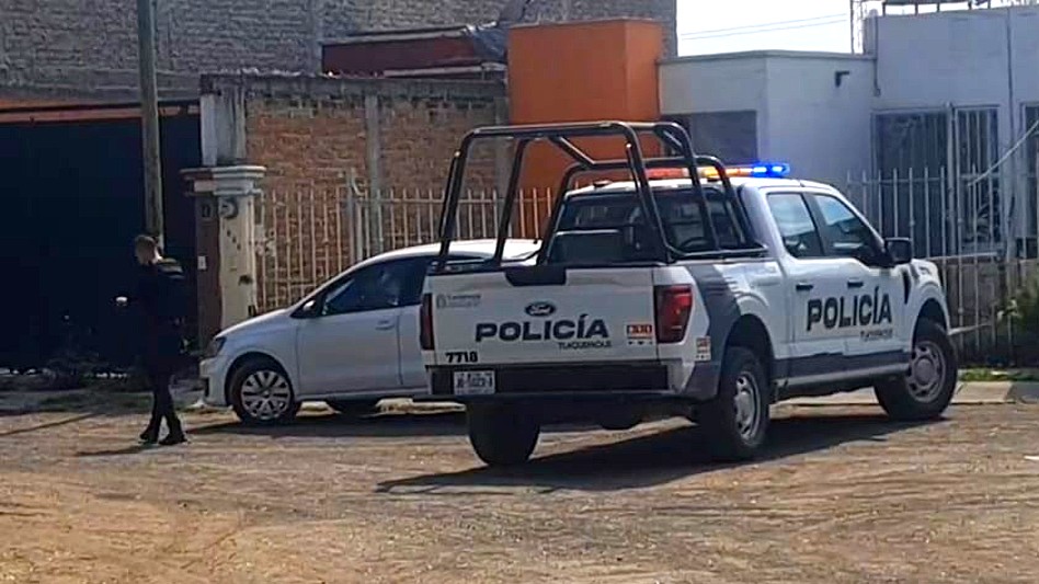 Patrulla de la Policía Municipal y oficial de Tlaquepaque frente a una casa y reja blanca en fraccionamiento Villa Fontana