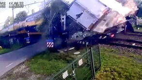 Tren amarillo impactando de lleno contra la caja de un camión blanco sobre las vías en Países Bajos