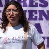Mujer de pelo rizado con lentes durante una protesta en Puebla.