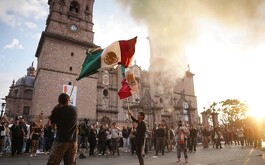Palacio de gobierno de Morelia, personas con banderas de México en las afueras