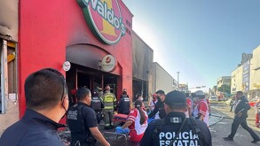 Fachada de Waldos destruida por el fuego y personal de Policía municipal.